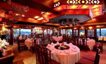 a large dining room with multiple tables and chairs arranged for a group of people to enjoy a meal at Pearl Hotel