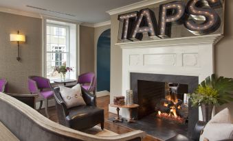 "a living room with a fireplace and a large letters spelling "" taps "" on the wall" at The Georges