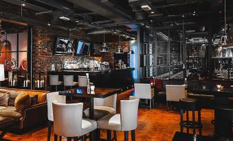 a well - lit restaurant with a bar area , featuring several chairs and tables set up for patrons at Dakota Eurocentral