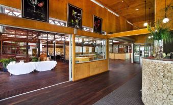a modern building with wooden floors and large windows , as well as framed art on the walls at Noosa North Shore Retreat