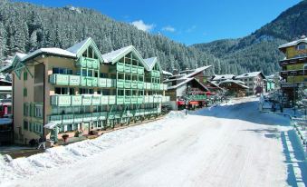 a snowy mountainous landscape with buildings and ski slopes , creating a picturesque winter scene at Hotel Dolomiti Schloss