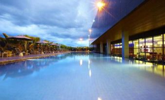 At night, a well-lit swimming pool is situated in front of a body of water, creating a visually appealing scene at Four Points by Sheraton Kuching