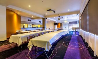 a large conference room with multiple long tables and chairs arranged for a meeting or event at Nightcap at Glengala Hotel
