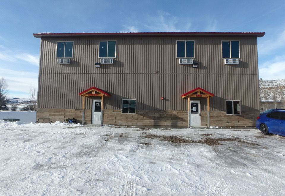 a large building with three windows , located on a snow - covered street in a city setting at Rays Place Inn