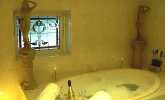 a luxurious bathroom with a large bathtub , two wine glasses , and a bottle of wine at Barossa Shiraz Estate