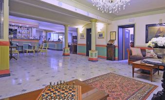 a large , well - lit hotel lobby with a chess game on a table and a bar area at Hotel Europa