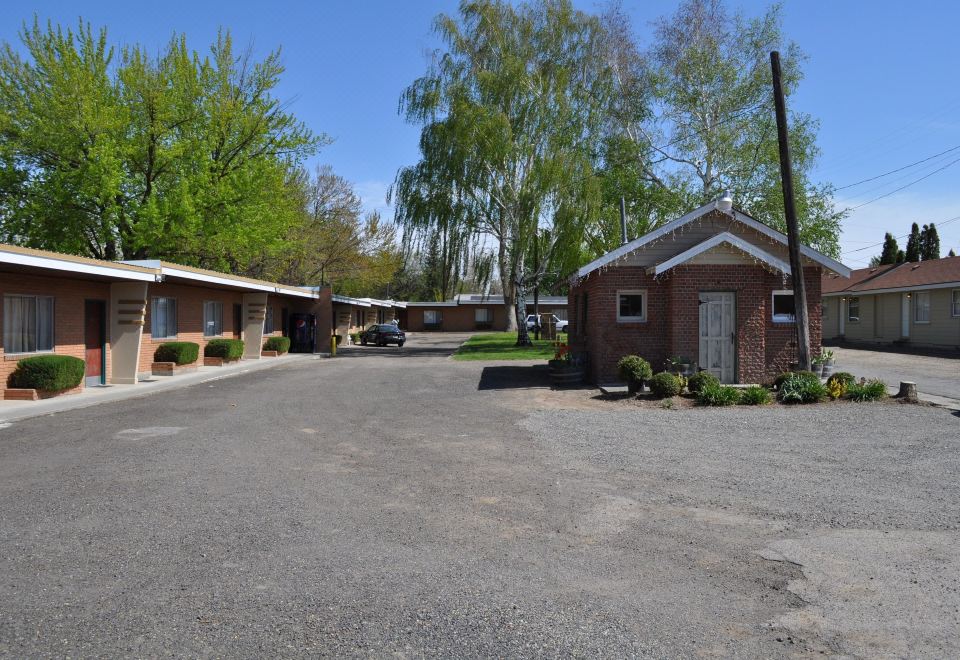 a brick building with a white roof is surrounded by trees and a parking lot at Wine Valley Inn