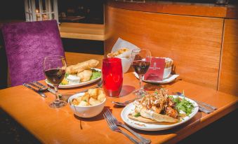 a wooden dining table with a variety of food items , including sandwiches , wine glasses , and bowls at Station House Hotel Letterkenny