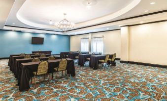 a conference room with blue walls , green and white patterned carpet , and tables set up for a meeting at La Quinta Inn & Suites by Wyndham Dallas Grand Prairie South