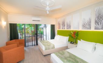 a hotel room with two beds , one on the left and one on the right side of the room at Cairns Colonial Club Resort