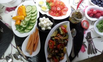 a table is filled with various dishes , including vegetables and meat , along with sauces and condiments at Hotel Bauer