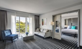 a modern living room with a couch , a tv , and a door leading to a balcony at InterContinental Sydney Double Bay, an IHG Hotel