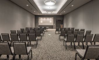 a large conference room with rows of chairs arranged in front of a projector screen at SpringHill Suites Dallas Rockwall
