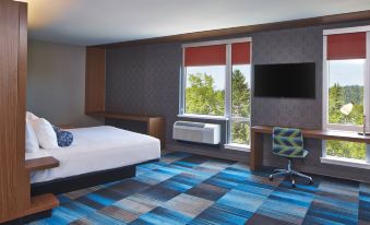 a modern hotel room with a bed , desk , and window , featuring blue and white checkered carpet at Aloft Seattle Redmond
