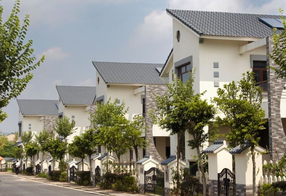 a row of modern houses with white walls and blue roofs are lined up along a street at Like Home Gedera