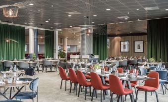 a large , open dining room with multiple tables and chairs arranged for a group of people to enjoy a meal together at Radisson Blu Airport Hotel, Oslo Gardermoen