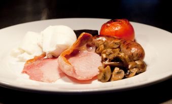 a white plate with a variety of food items , including ham , mushrooms , tomatoes , and mozzarella at The Punch Bowl Inn