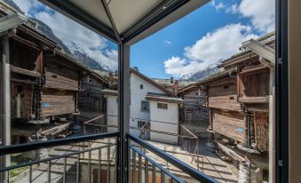 a balcony overlooking a small town with a mix of old and new architecture , creating a quaint and picturesque scene at Hotel Heimatlodge