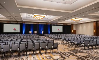 a large conference room with rows of chairs arranged in front of a stage , and a podium at the front at Hyatt Regency Coralville Hotel & Conference Center