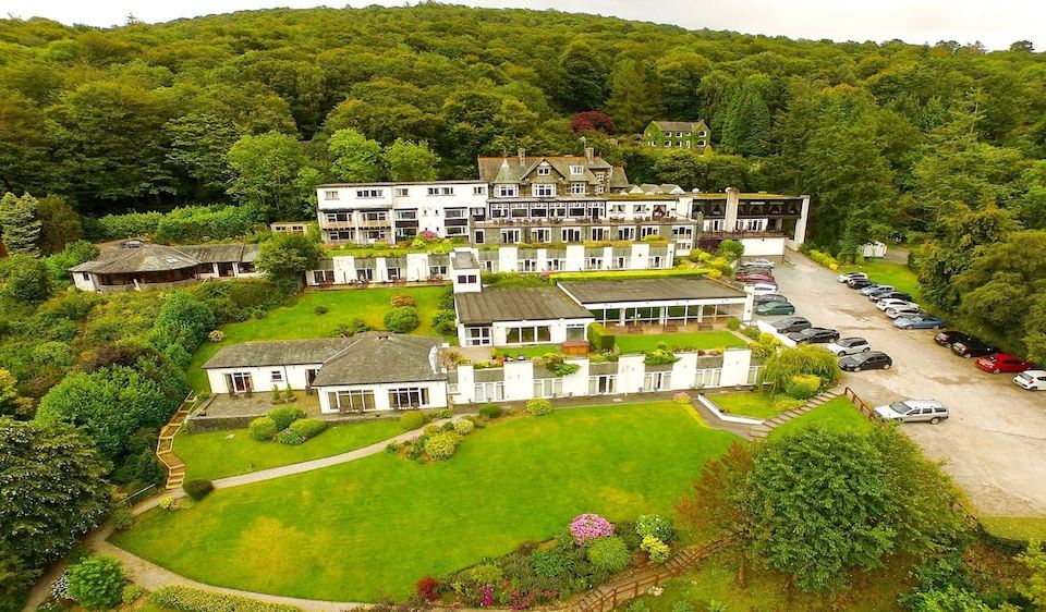 an aerial view of a large , white building surrounded by trees and greenery , with multiple cars parked in front of it at Beech Hill Hotel & Spa