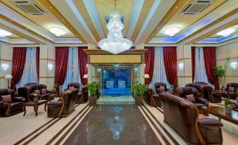 a large hotel lobby with high ceilings , leather couches , and a crystal chandelier hanging from the ceiling at Semeli Hotel