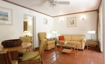 a living room with a couch , chairs , and a coffee table in front of a window at The Palms Resort