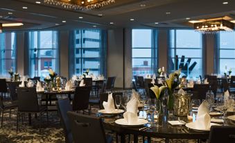 a large dining room with multiple tables set for a formal dinner , complete with wine glasses and elegant decorations at Renaissance Allentown Hotel