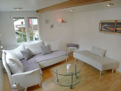 a white living room with a large window , two couches , and a coffee table , creating a cozy atmosphere at Marilyn Visperterminen