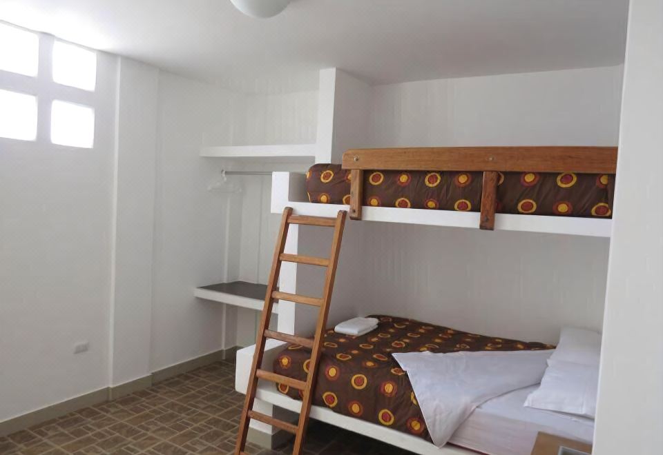 a small room with two bunk beds , one on top of the other , and a ladder leading to the top bunk at Costa Esmeralda