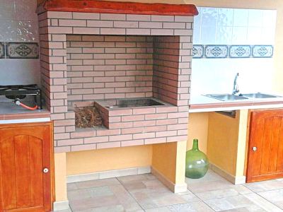 a brick oven is situated in a kitchen with a sink and a vase on the counter at Titi Titi Photo