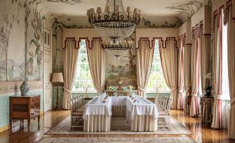 a formal dining room with a long table and multiple chairs arranged for a meal at Valverde Sintra Palácio de Seteais