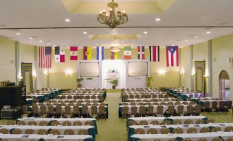 a large , well - lit conference room with rows of chairs arranged in a semicircle , and a podium at the front at Melia Panama Canal