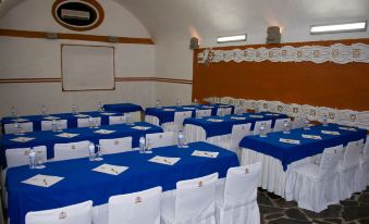 a conference room set up for a meeting , with multiple tables and chairs arranged in rows at Hotel Hacienda Vista Hermosa