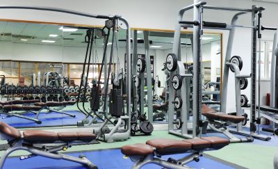 a well - equipped gym with various exercise equipment , such as weightlifting machines and benches , arranged in a spacious room at Village Hotel Liverpool