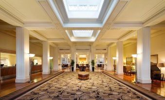 a large , elegant lobby with high ceilings and columns , featuring a carpeted floor and a high ceiling at Hyatt Hotel Canberra - A Park Hyatt Hotel