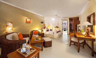 a luxurious hotel room with a king - sized bed , a couch , and a dining table in the living area at Holiday Resort Lombok