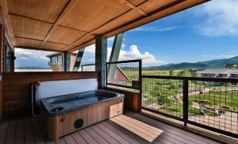 a wooden deck with a hot tub , surrounded by a spacious house and enjoying the view of the mountains at Newpark Resort