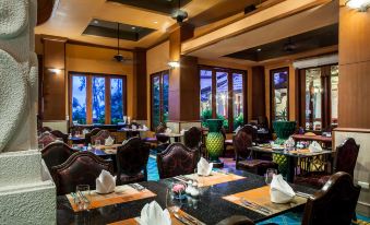 a restaurant with tables and chairs in the center, as well as additional seating areas for customers at Novotel Phuket Resort