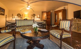 a cozy living room with a round coffee table in the center , surrounded by chairs and couches at Hacienda San Gabriel de las Palmas