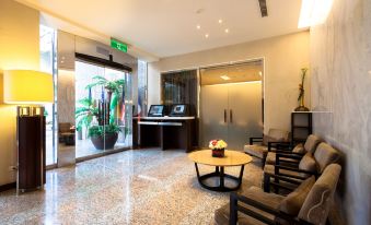 a modern hotel lobby with a check - in desk and several chairs arranged around it , creating a welcoming atmosphere at Sol Hotel