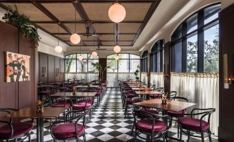 a large dining room with numerous tables and chairs arranged for a group of people to enjoy a meal together at The Dewberry Charleston