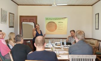 a group of people are sitting in a room with a woman giving a presentation at Bilpin Country Lodge