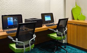 a room with three computer desks , each equipped with a computer monitor , keyboard , and mouse at Sonesta Select Seattle Renton Suites