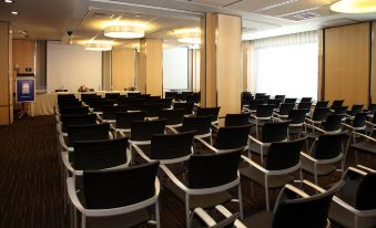 a large conference room with rows of chairs arranged in a semicircle , and a podium at the front of the room at Invisa Hotel la Cala