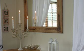a wooden mirror with a mirror frame and three lit candles on a wooden table at MRS Simpson