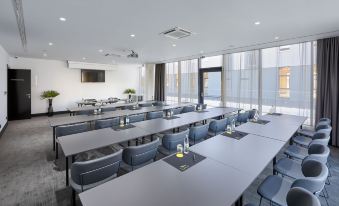 a conference room with multiple tables and chairs , set up for a meeting or presentation at Sia Split Hotel