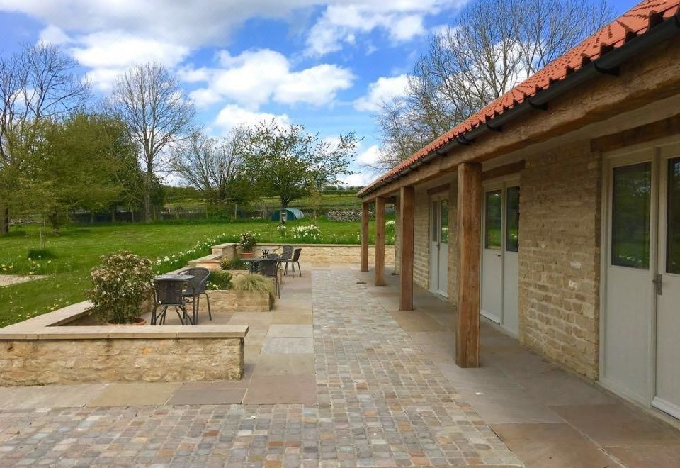 a paved walkway leading to a covered area , with several chairs placed around it for outdoor relaxation at The Horseshoe Country Inn