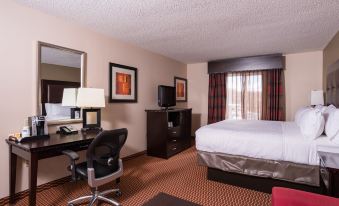 a hotel room with a bed , desk , and chair , as well as various office supplies and decorations at Holiday Inn Express Newington - Hartford