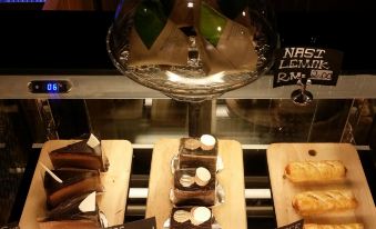 a display case filled with various types of desserts , including cakes and pastries , in a bakery at Go Hotel