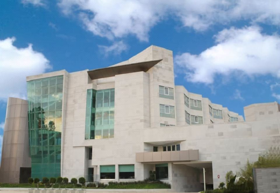 a large white building with a modern design , situated in front of a blue sky at Hotel Madeira